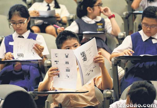 小学组参赛者参加“华文大比拼”笔试，题型包括翻译与看图猜成语。（梁麒麟摄）
