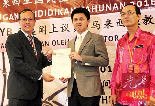 张盛闻（中）颁发参与证书予陈德祥，右为林兴南。（马来西亚《光华日报》）