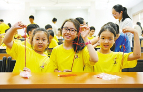 在慈湖中学，季婷婷（中）与小伙伴们第一次学打中国结。(张燕