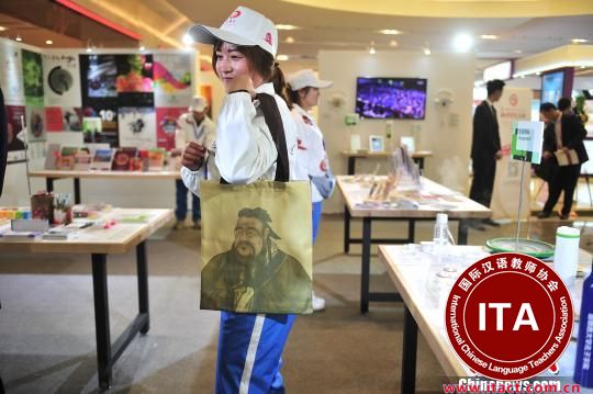 中国侨网志愿者展示孔子图案背包。　刘冉阳　摄