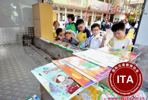 中国侨网学生对流动图书馆内的绘本爱不释手。（马来西亚《星洲日报》）