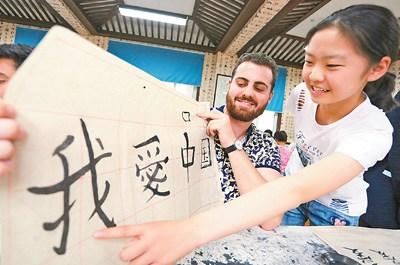 中国侨网图为来自澳大利亚的支教生展示自己书写的毛笔字。  　　人民视觉