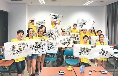 中国侨网中级五班的同学开心地展示他们的国画作品。李双倾摄