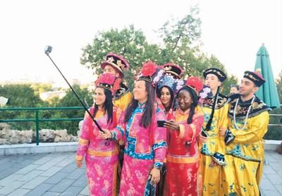 中国侨网身穿中国古代皇宫服饰的外国友人在北京景山公园自拍留念。 本报记者 高炳 摄