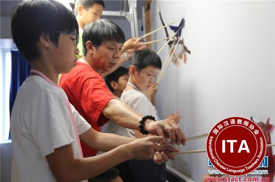 湖南省木偶皮影艺术保护传承中心的彭泽科老师手把手地教孩子们做皮影、演皮影。　张婧 摄