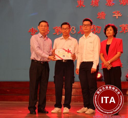 潮州会馆副会长黄焕明为毕业生颁发毕业证书。(柬埔寨《星洲日报》图片)