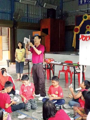 友族学生也穿上红彤彤的衣服，学习剪纸中华文化。（马来西亚《光华日报》）